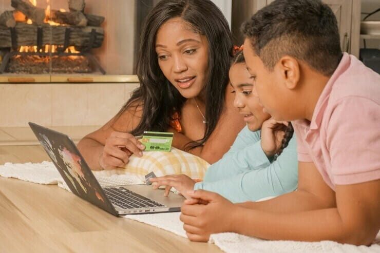 genitori e figlia che usano un laptop insieme