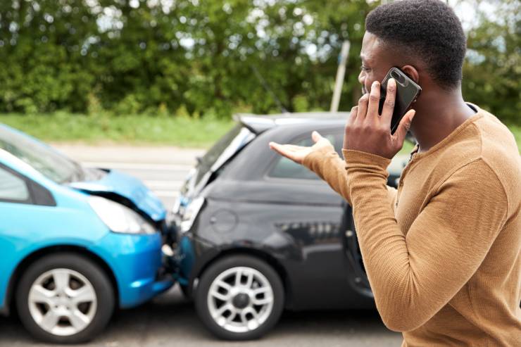 Ragazzo che chiama i vigili dopo un'incidente stradale