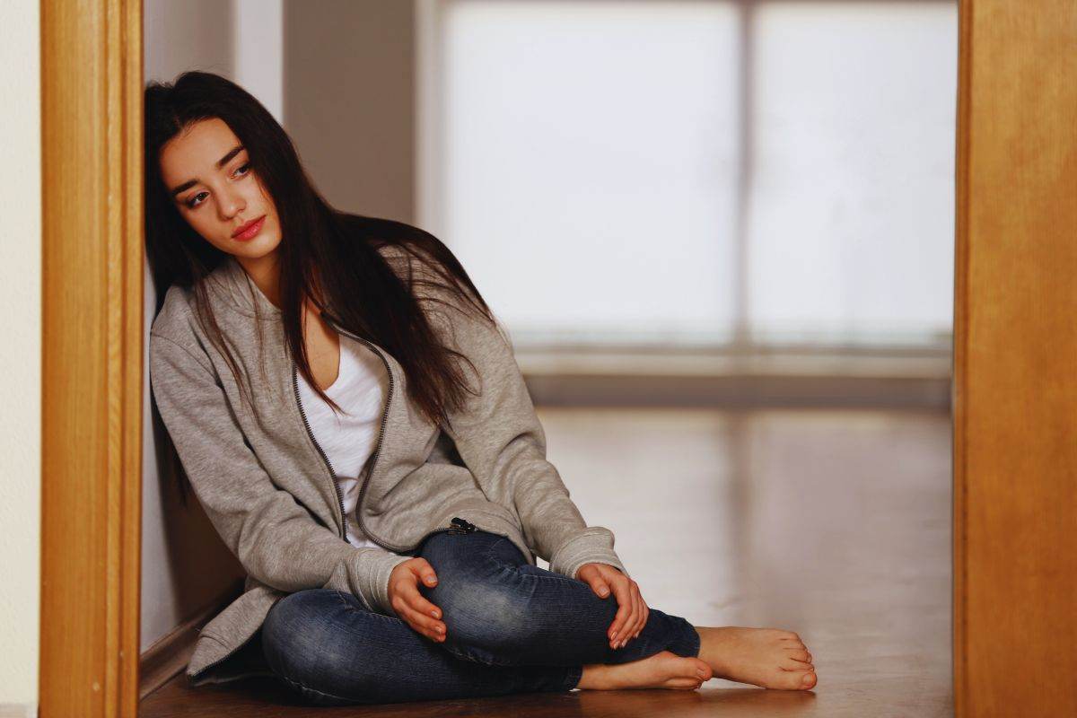 donna poggiata su stipite della porta