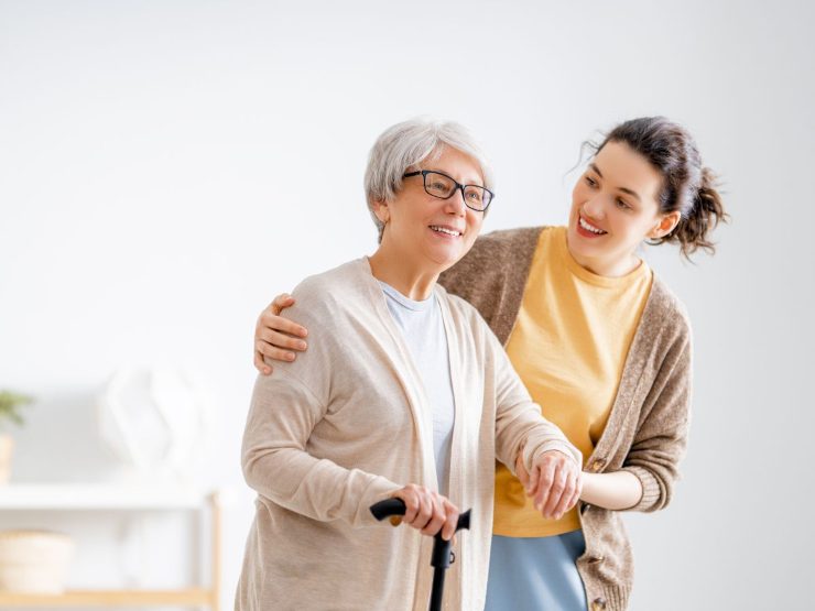 Donna che regge persona anziana