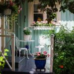 Balcone con diverse piante, un tavolino e una sedia