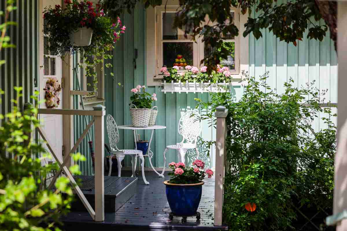 Balcone con diverse piante, un tavolino e una sedia