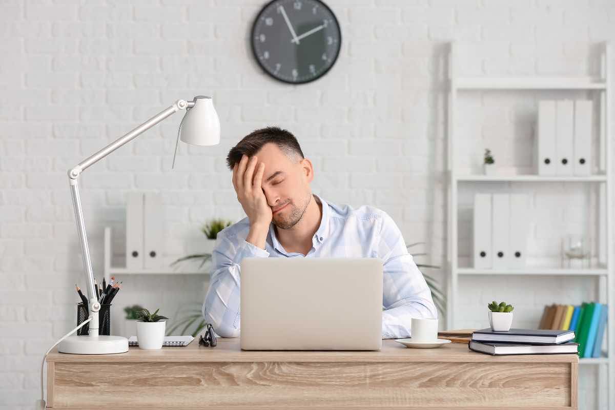 Uomo stanco di fronte al computer