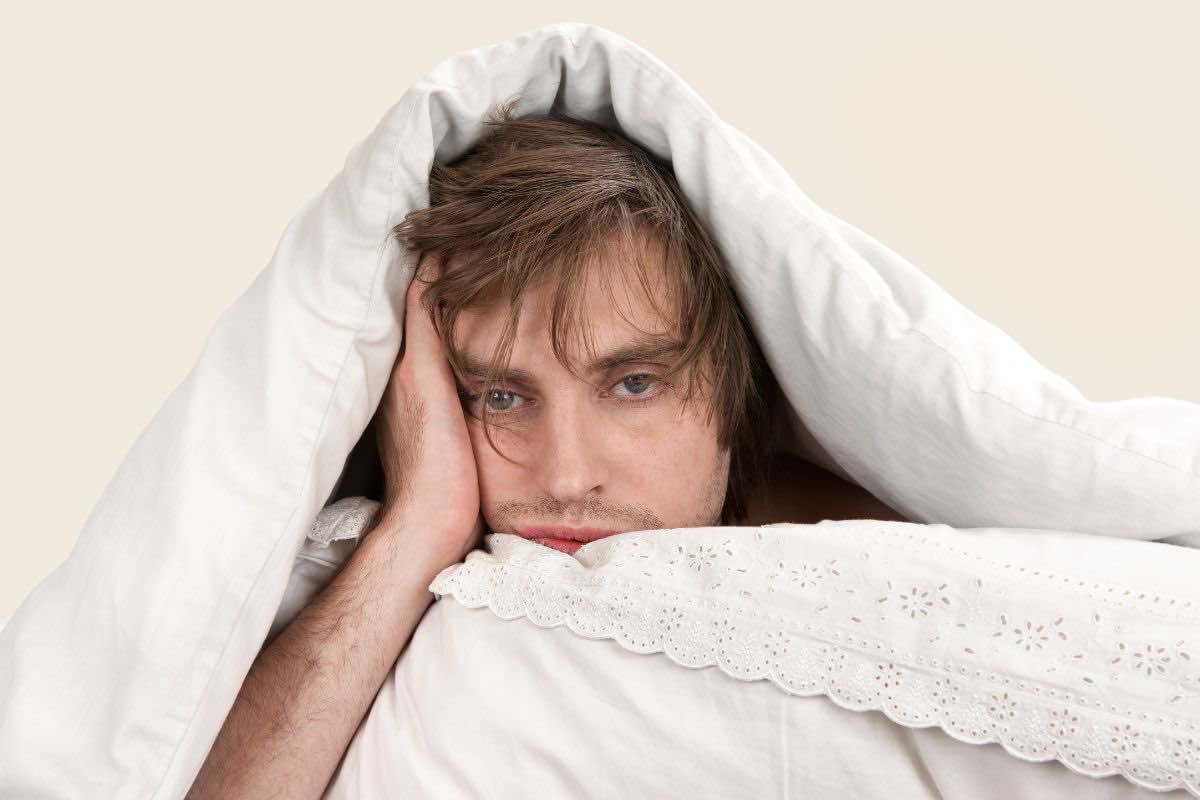 Uomo sotto le coperte