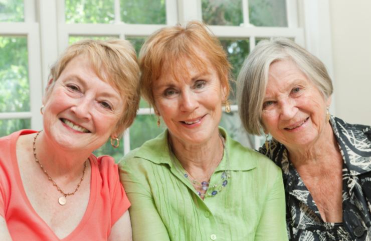 tre donne anziane che sorridono una accanto all'altra