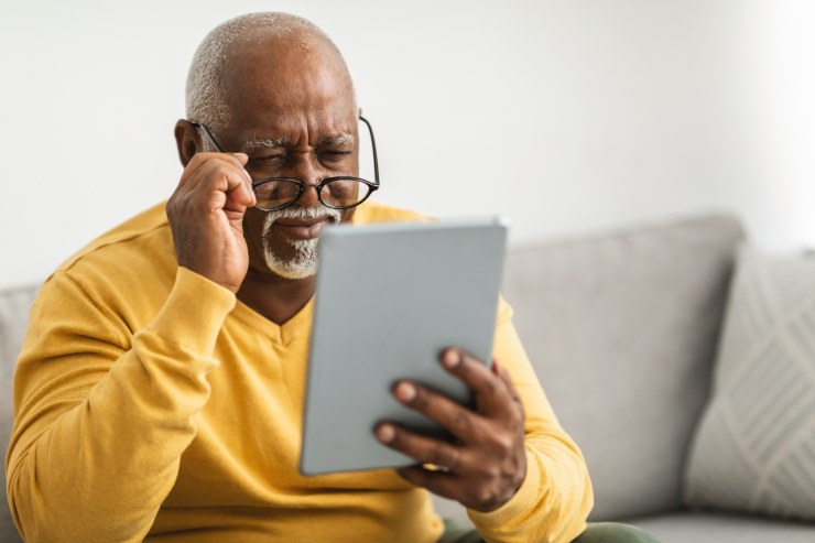 uomo con occhiali controlla il tablet