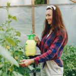 ragazza che spruzza un prodotto sulle piante