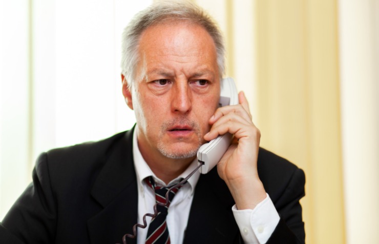 uomo al telefono con espressione preoccupata